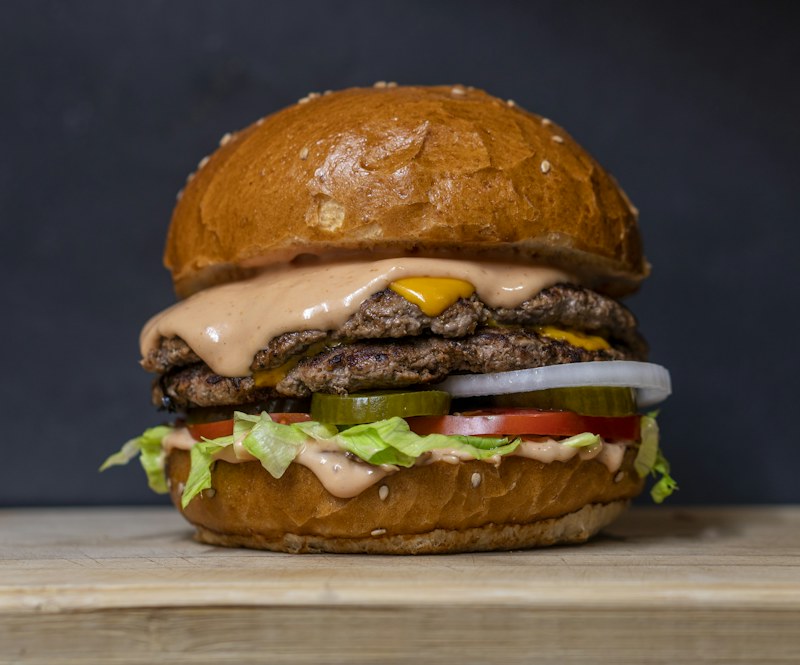 A stacked burger with fresh toppings